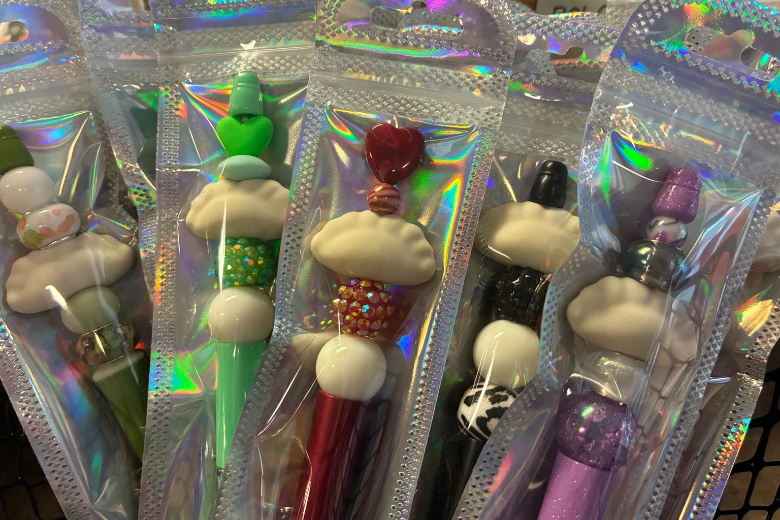 Colorful novelty pens packaged in holographic sleeves and displayed together at Kat’s Café & Restaurant. Colorful novelty pens packaged in holographic sleeves and displayed together at Kat’s Café & Restaurant.