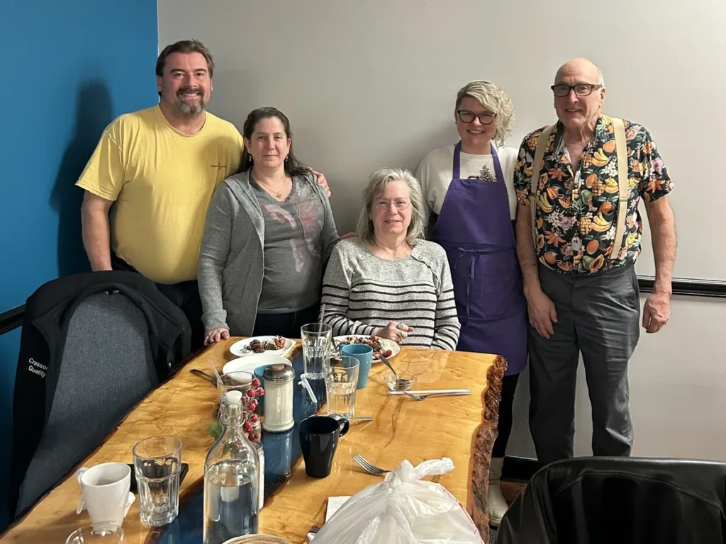 Guests smiling after a meal with the chef-owner at Kat’s Café & Restaurant.