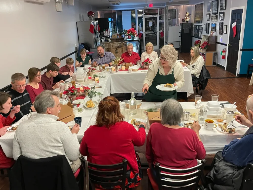 Chef Kat serving homemade dessert as the final course during a holiday event meal at Kat’s Café & Restaurant.