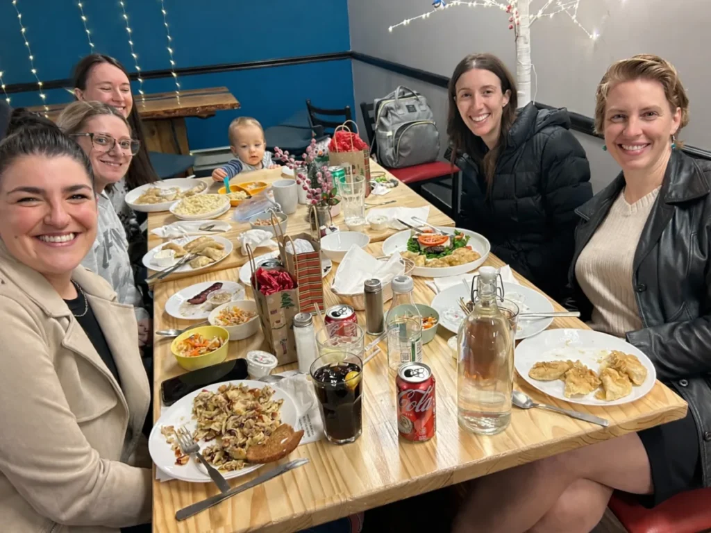 Guests smiling around a table with pierogies and homemade comfort food at Kat’s Café & Restaurant.