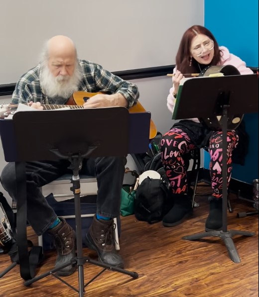 Live music duet at Kat’s Café & Restaurant with both musicians seated and the man playing the guitar while the female sings and plays the tambourine.