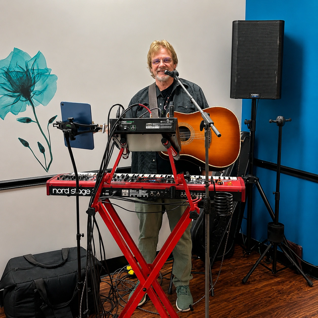 Solo musician singing and playing acoustic guitar behind a red keyboard setup during a live music performance at Kat’s Café & Restaurant.