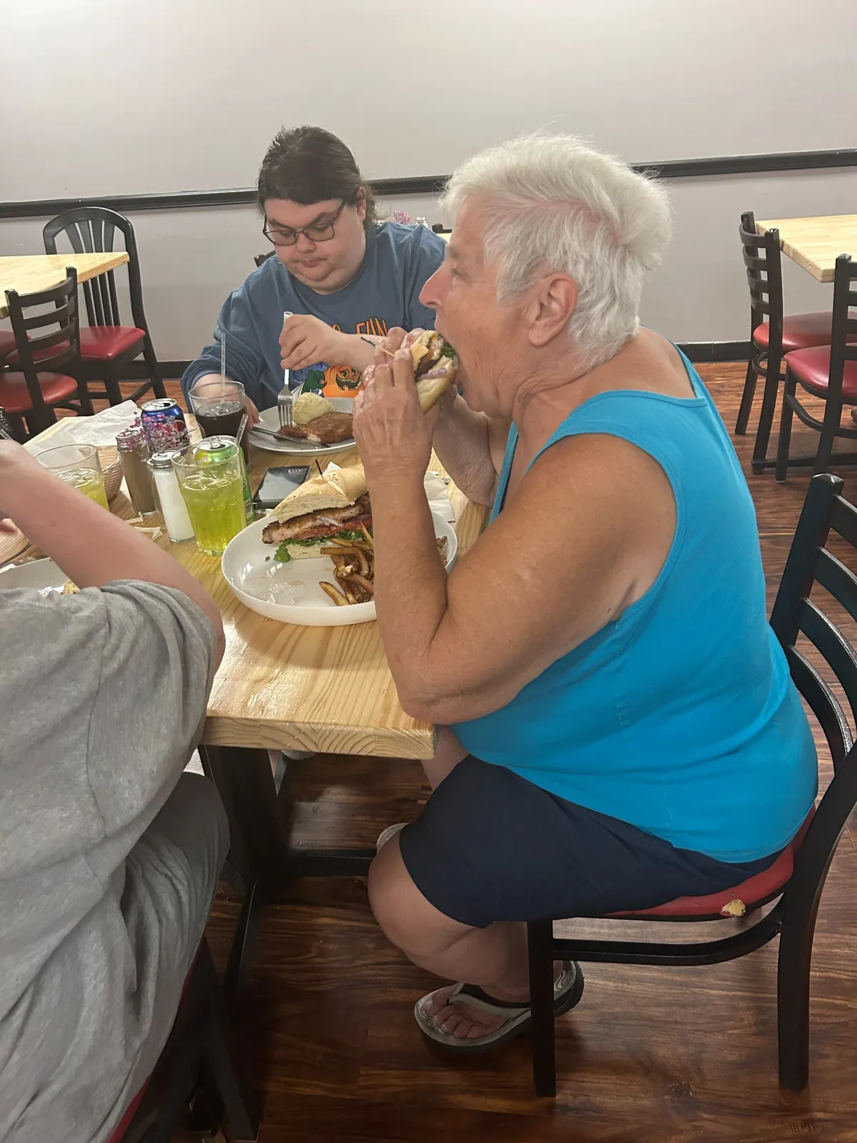 Guests dining at Kat’s Café & Restaurant with a pork schnitzel sandwich and plated schnitzel meal.