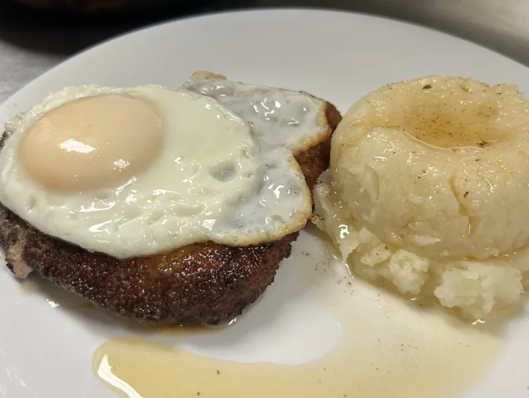 Pork schnitzel topped with a fried egg, served with mashed potatoes and gravy at Kat’s Café & Restaurant.