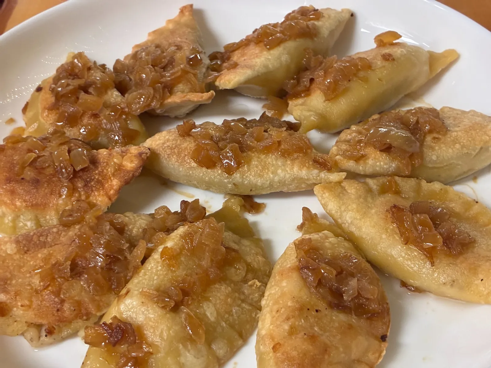 Plate of pan-fried handmade pierogies topped with sautéed onions and butter at Kat’s Café & Restaurant.