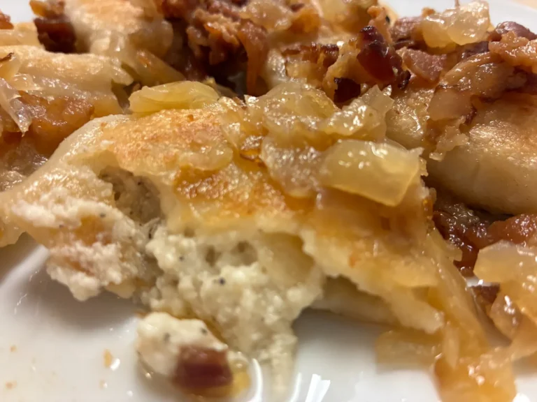 Close-up of a potato and cheese pierogi cut open and topped with onions and crumbled bacon at Kat’s Café & Restaurant.