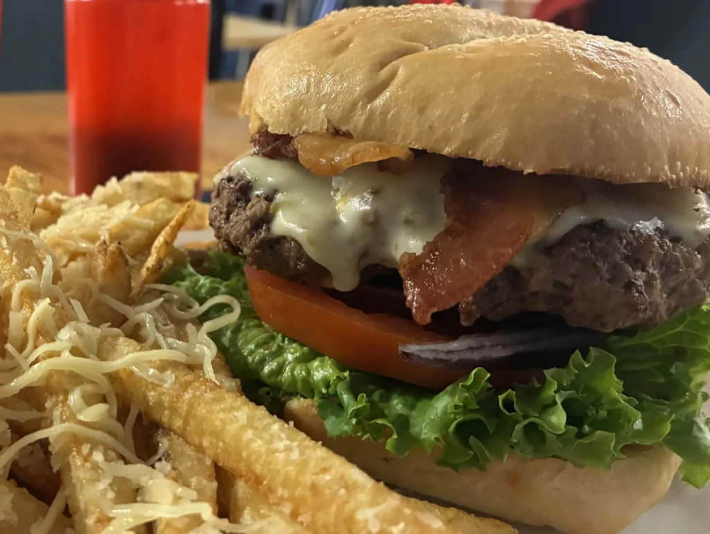 Bacon cheeseburger with melted cheese, lettuce, tomato, and red onion, served with Parmesan-topped fries at Kat’s Café & Restaurant.