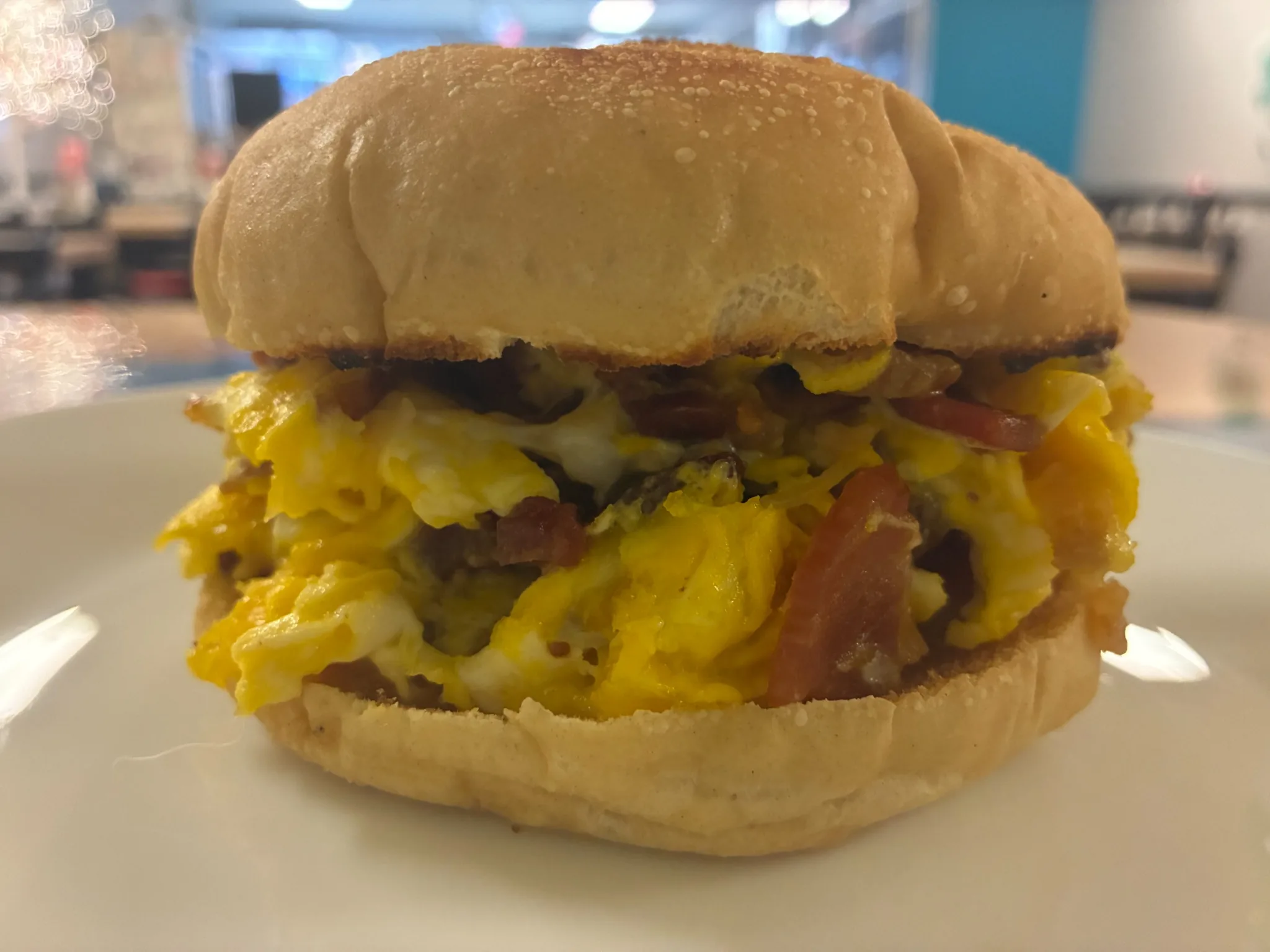 Breakfast sandwich on a roll filled with scrambled eggs, bacon, and melted cheese served at Kat’s Café & Restaurant.