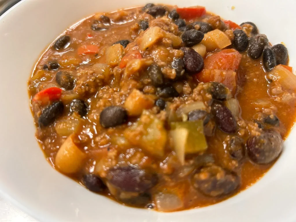 Hearty beef chili with black beans, vegetables, and a rich tomato base in a white bowl at Kat’s Café & Restaurant.