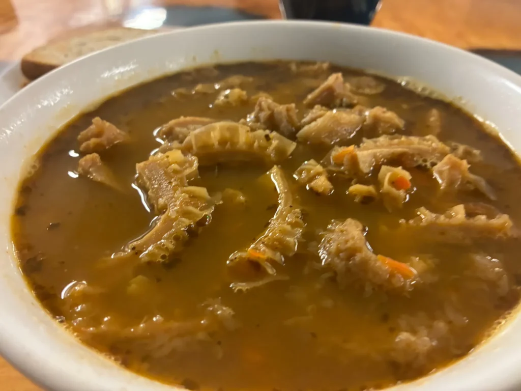 Polish beef tripe soup with strips of tripe in a seasoned broth in a white bowl at Kat’s Café & Restaurant.