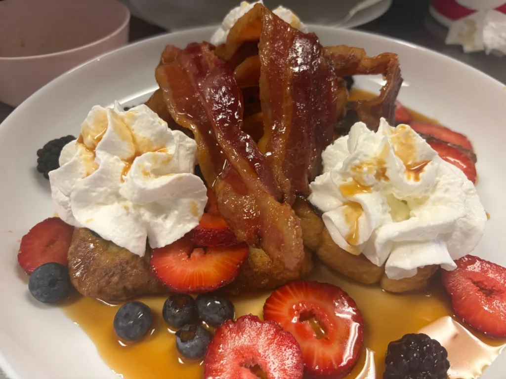 French toast topped with maple bacon, whipped cream, strawberries, blueberries, blackberries, and real PA maple syrup served at Kat’s Café & Restaurant.