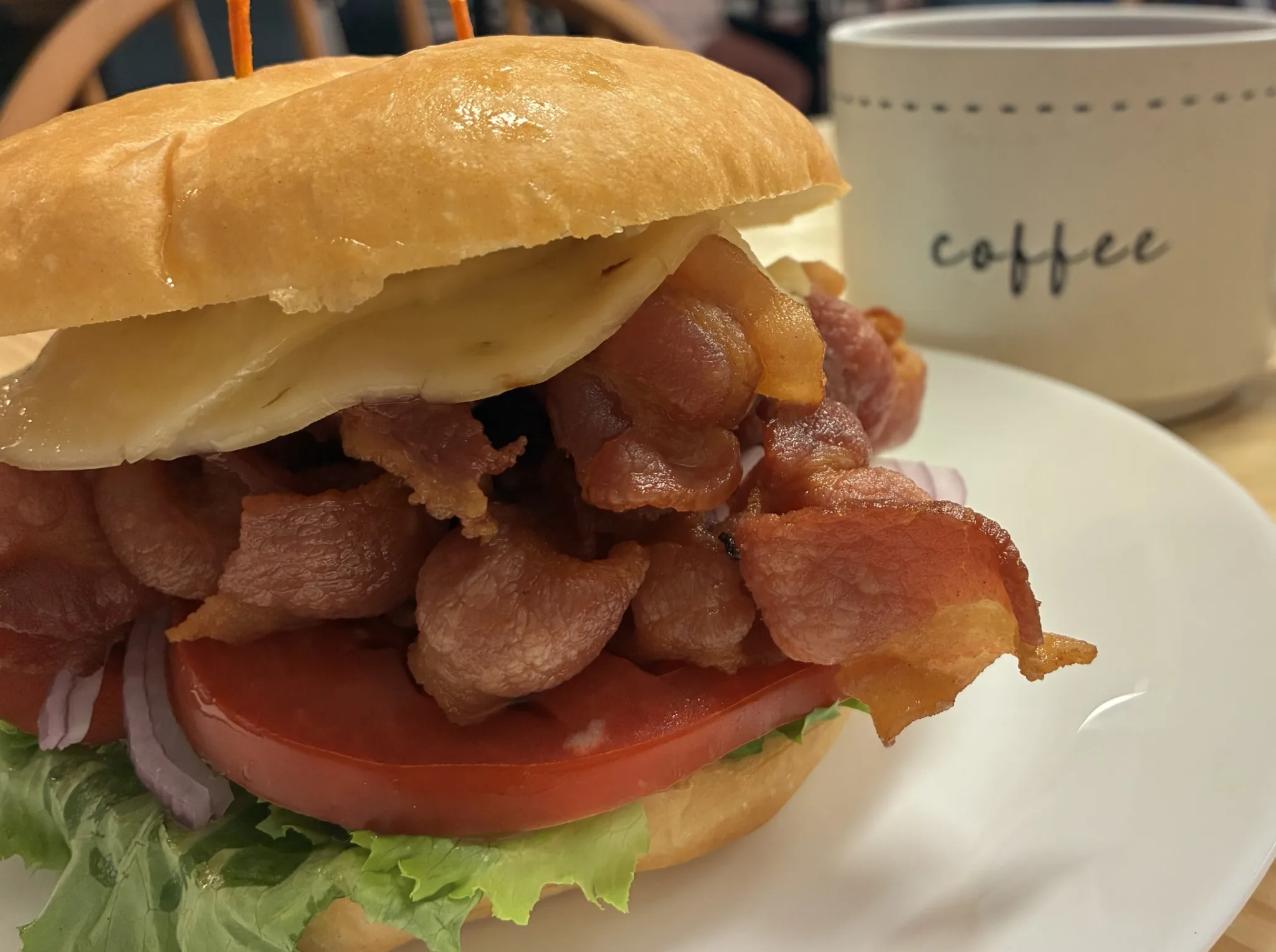 Tuna salad sandwich with lettuce, tomato, red onion, and mixed greens on a round roll at Kat’s Café & Restaurant.