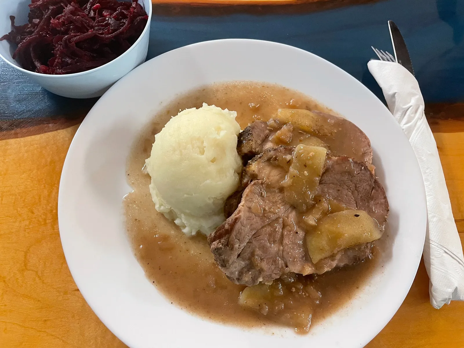 Slices of braised pork with pan gravy, mashed potatoes, and a traditional beet side at Kat’s Café & Restaurant.