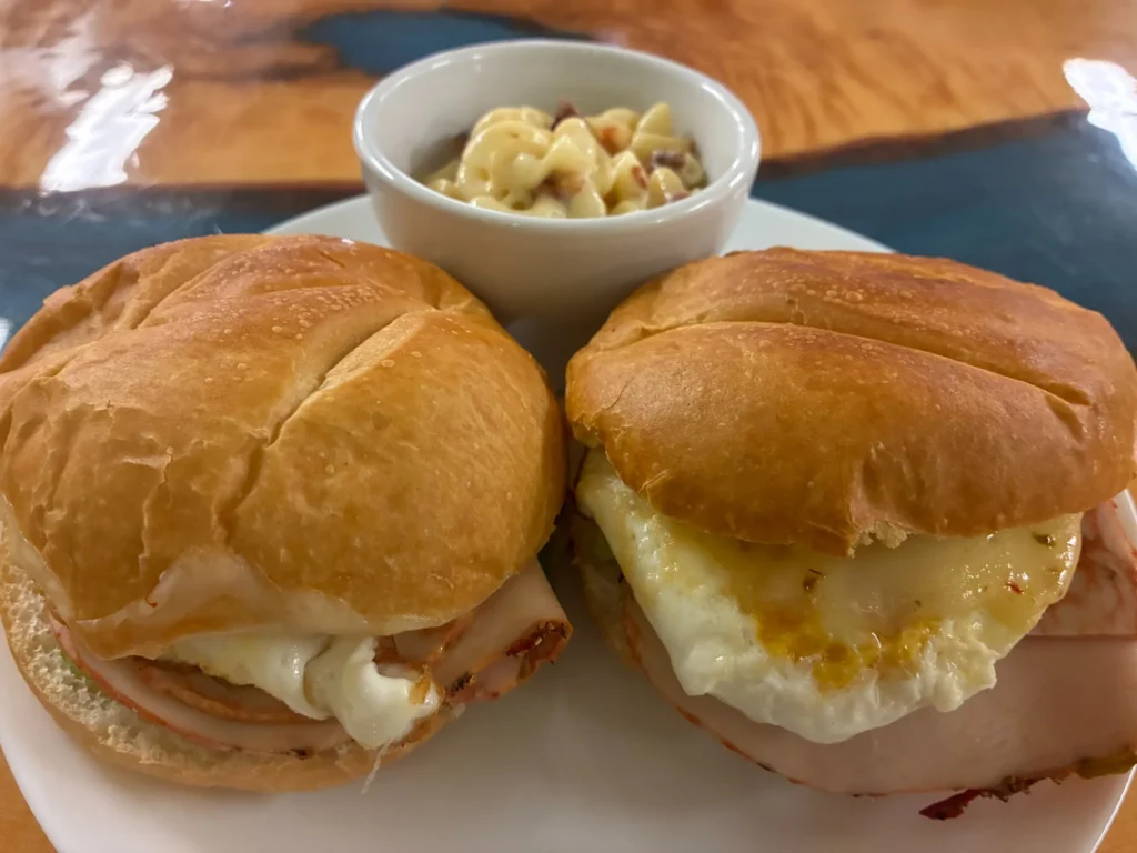 Two breakfast sandwiches on rolls served with a small bowl of macaroni and cheese at Kat’s Café & Restaurant.