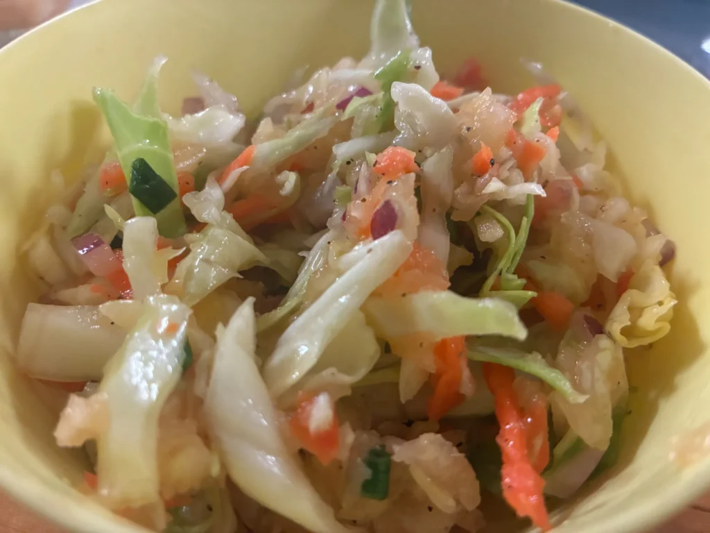 Bowl of lightly dressed cabbage slaw with carrot and onion at Kat’s Café & Restaurant.