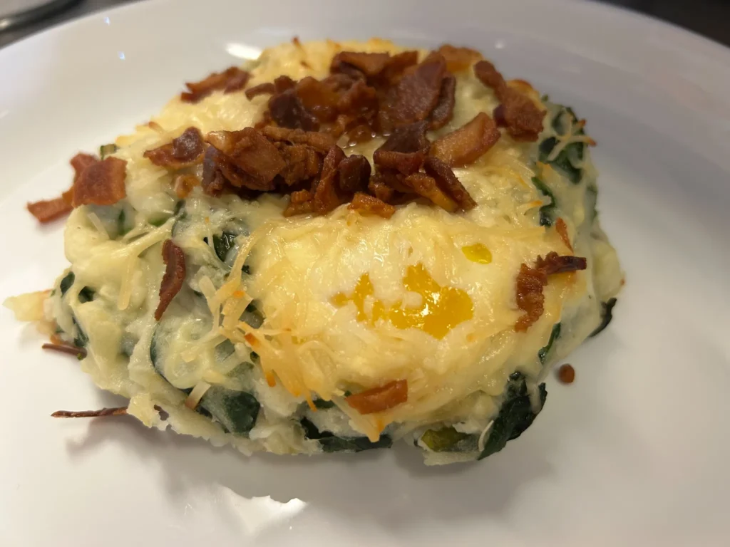 Potato, spinach, egg, and cheese brunch bake topped with crisp bacon at Kat’s Café & Restaurant.
