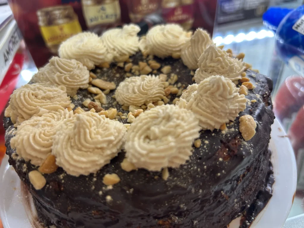 Chocolate cake topped with peanut butter-style frosting rosettes and chopped nuts at Kat’s Café & Restaurant.