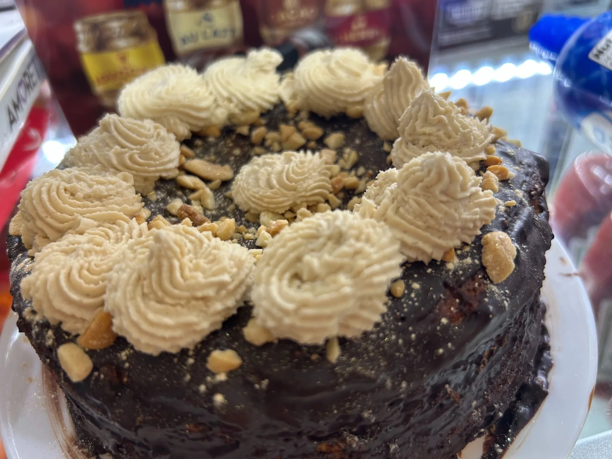 Chocolate cake topped with peanut butter-style frosting rosettes and chopped nuts at Kat’s Café & Restaurant.