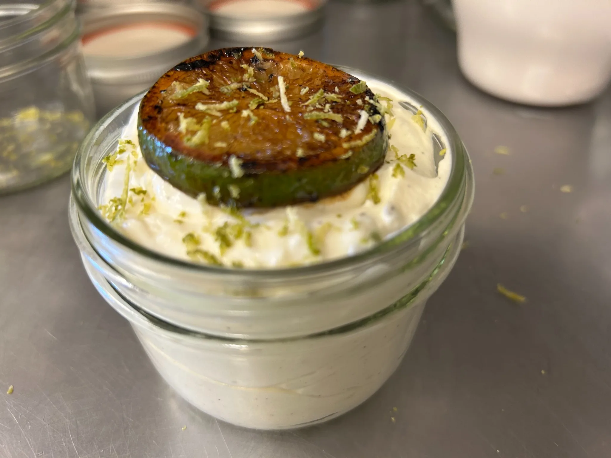 Citrus cream dessert in a glass jar topped with a caramelized citrus slice and zest at Kat’s Café & Restaurant.