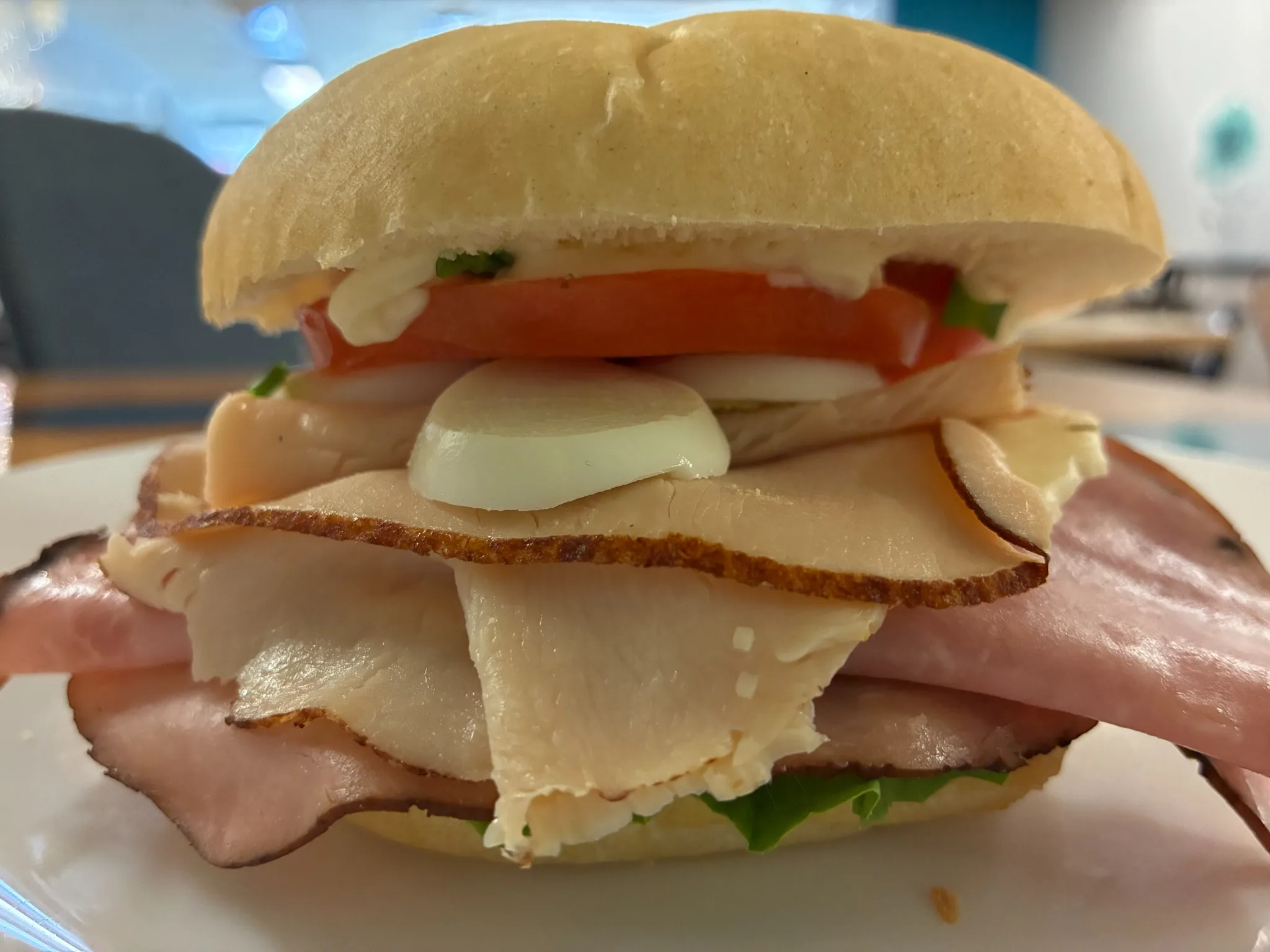 Cold-cut sandwich with assorted sliced meats, cheese, hard-boiled egg, tomato, lettuce, and creamy mayo on a bakery roll at Kat’s Café & Restaurant.