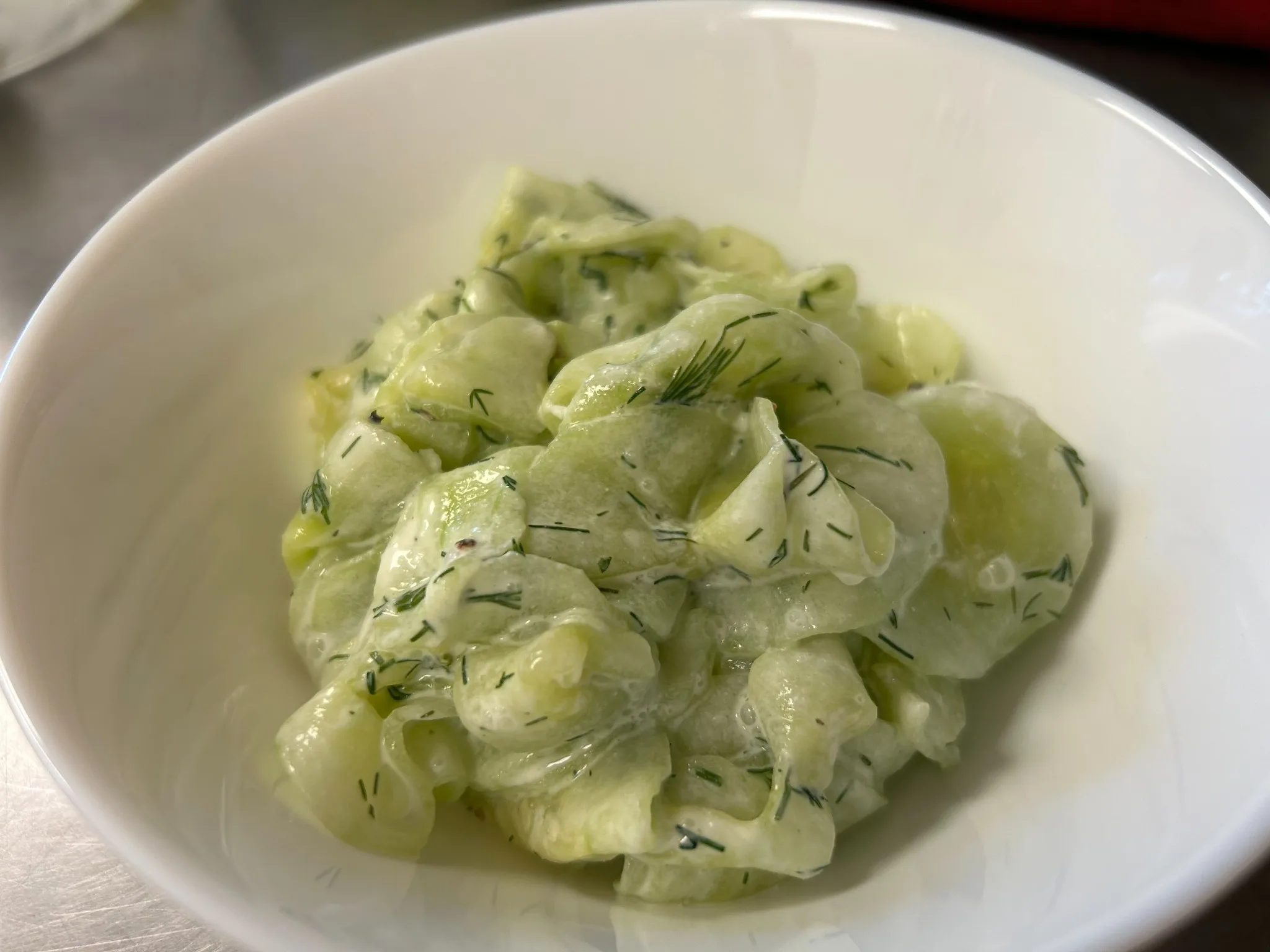 Bowl of cucumber dill salad in a creamy dressing at Kat’s Café & Restaurant.