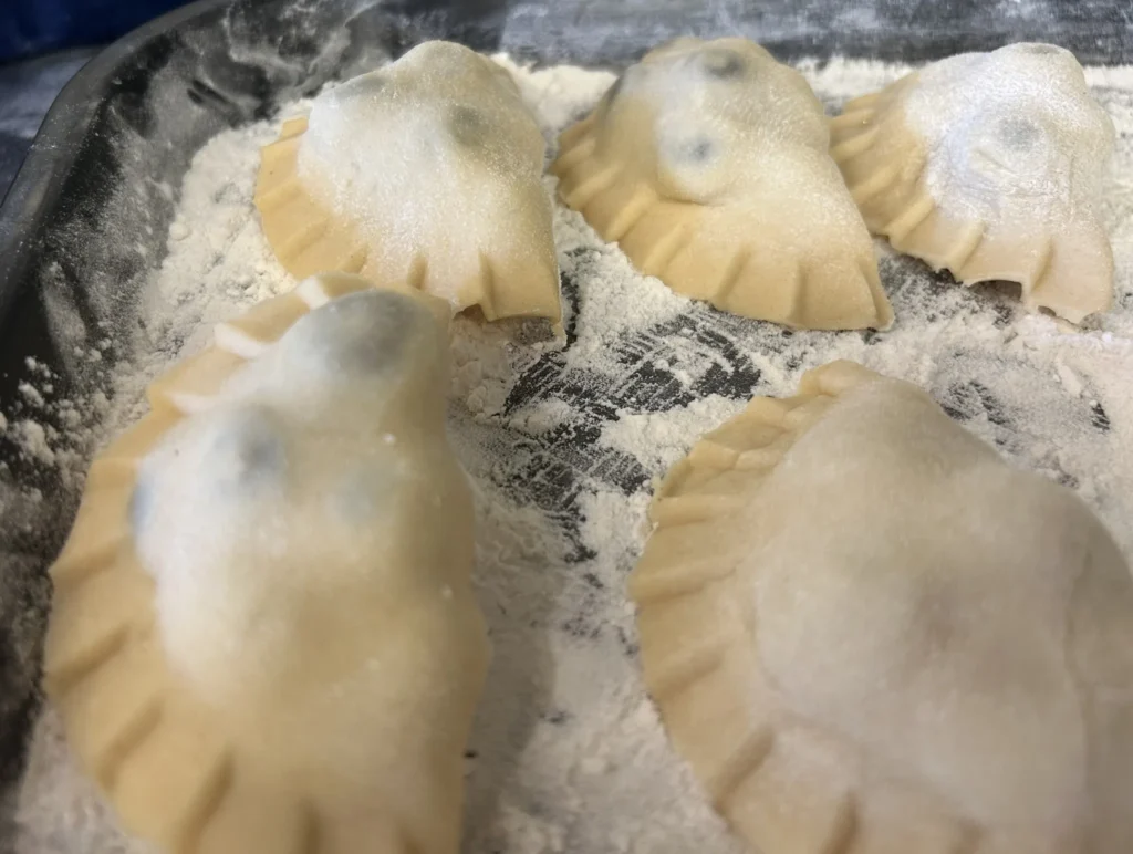 Freshly formed pierogies resting on a floured tray before cooking at Kat’s Café & Restaurant.