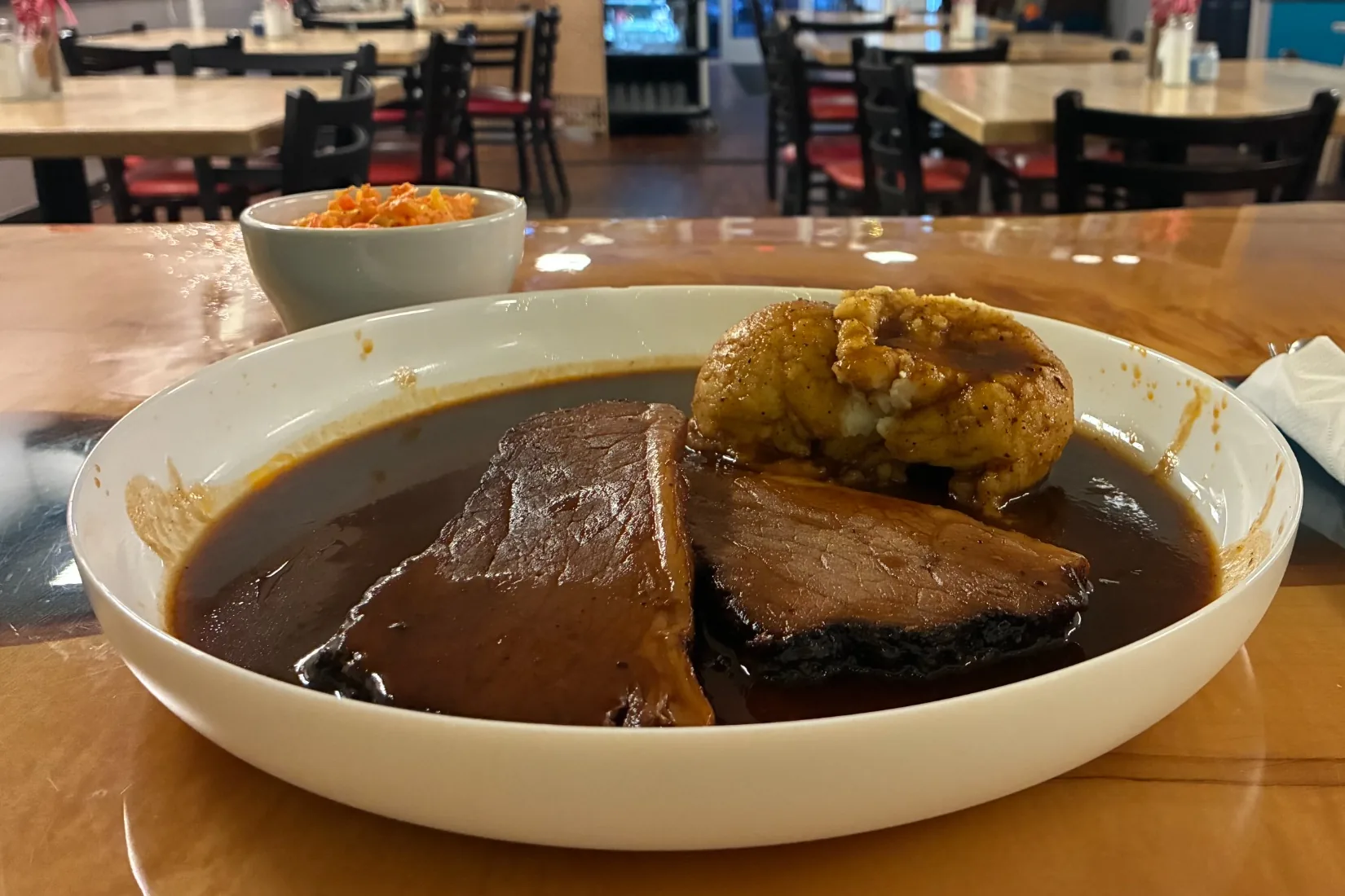 Homestyle smoked beef brisket dinner in rich homemade bbq gravy sauce, served with sides inside Kat’s Café & Restaurant.