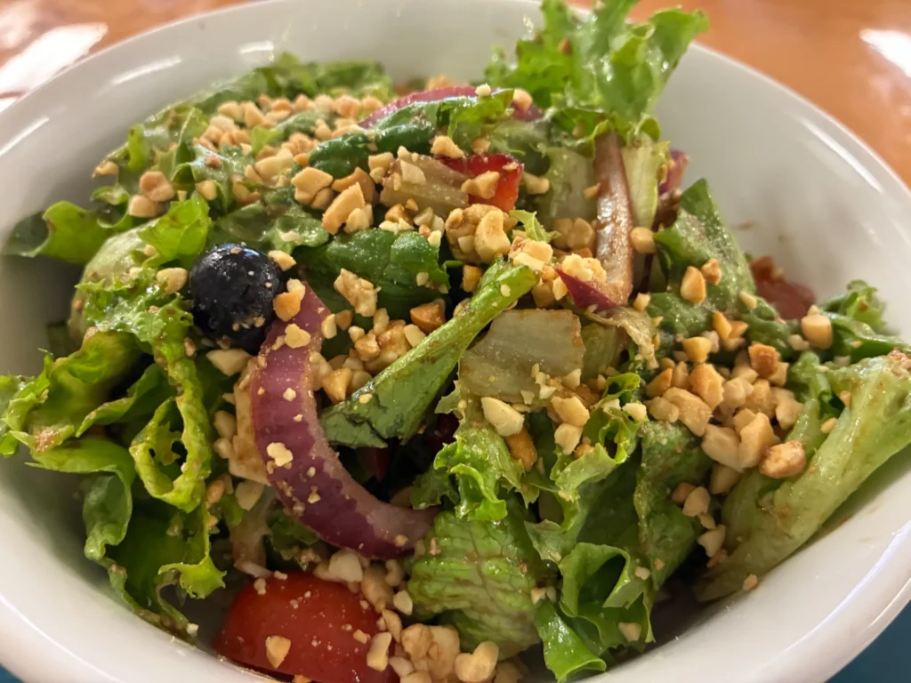 Mixed green salad with lettuce, tomato, red onion, blueberries, and chopped nuts at Kat’s Café & Restaurant.
