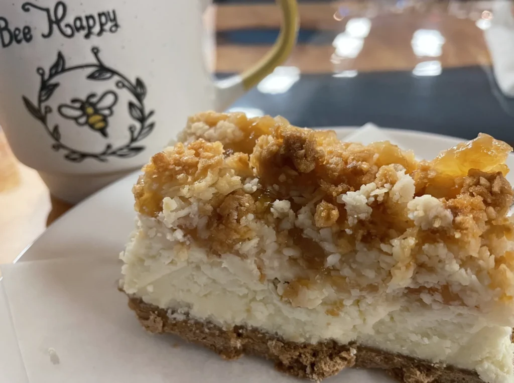 Slice of pineapple-coconut crumb cheesecake on a white plate at Kat’s Café & Restaurant.