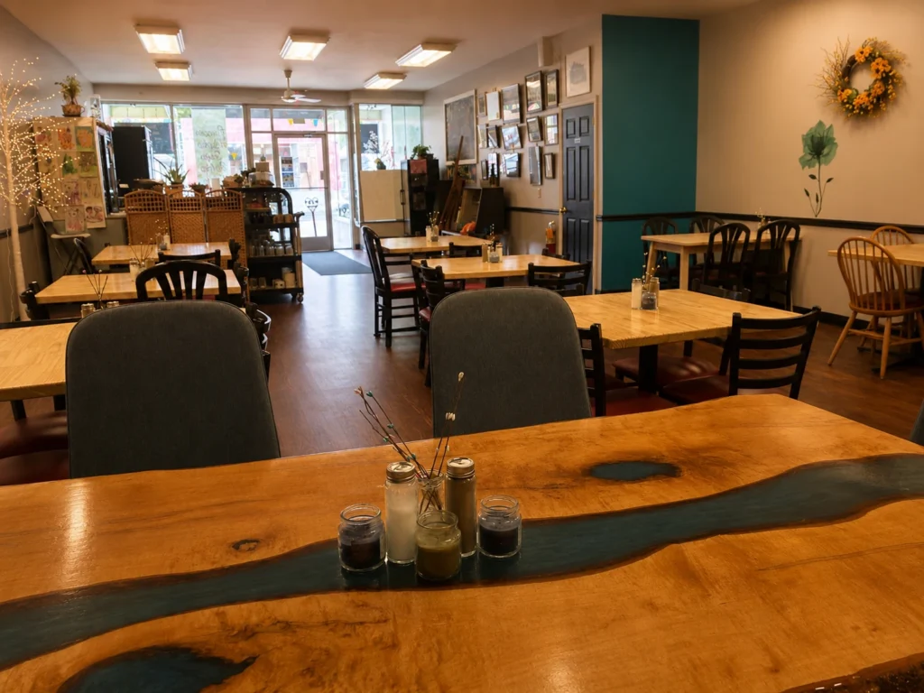 Warm dining room inside Kat’s Café & Restaurant in Minersville, Pennsylvania, with wooden tables, teal accents, and a welcoming front entrance.