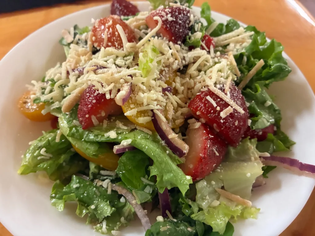 Fresh salad with strawberries, tomatoes, red onion, lettuce, and grated Parmesan at Kat’s Café & Restaurant.