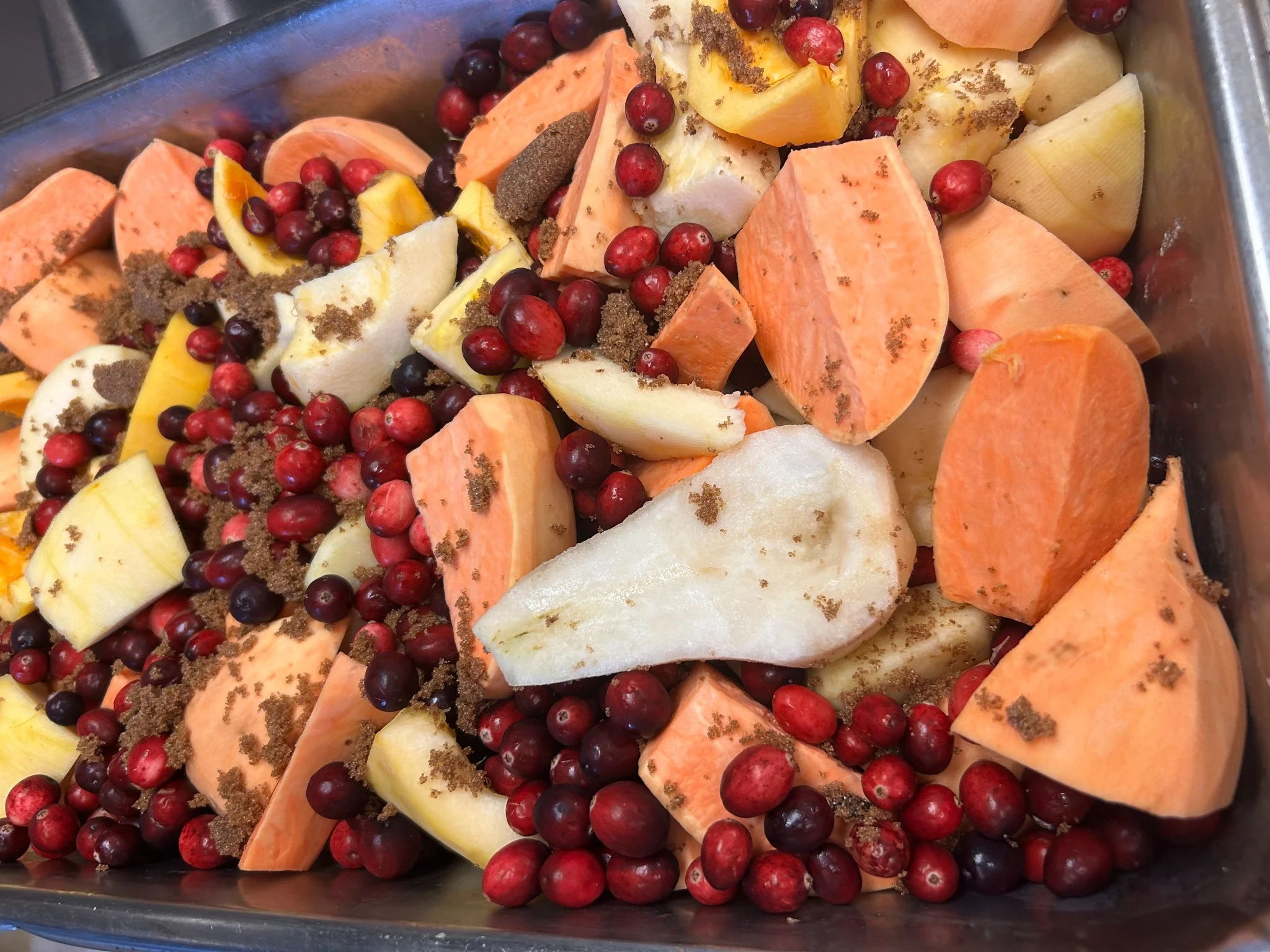 Sweet potatoes, pears, apples, cranberries, brown sugar, and other natural ingredients in a deep oven pan prepared for Kat’s Thanksgiving dinner.
