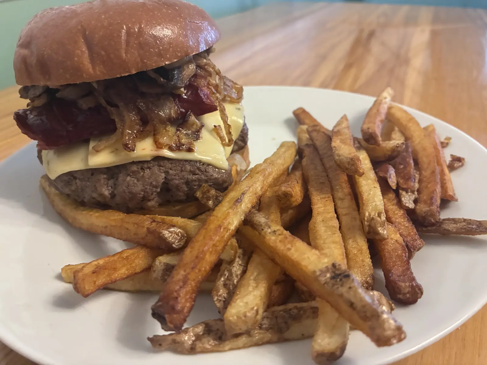 Kat’s Kielbasa Burger with a beef smash patty, grilled Polish kielbasa, melted cheese, Slavic mustard, caramelized onions, and homemade sauerkraut on a toasted bun, served with skin-on fries at Kat’s Café & Restaurant.
