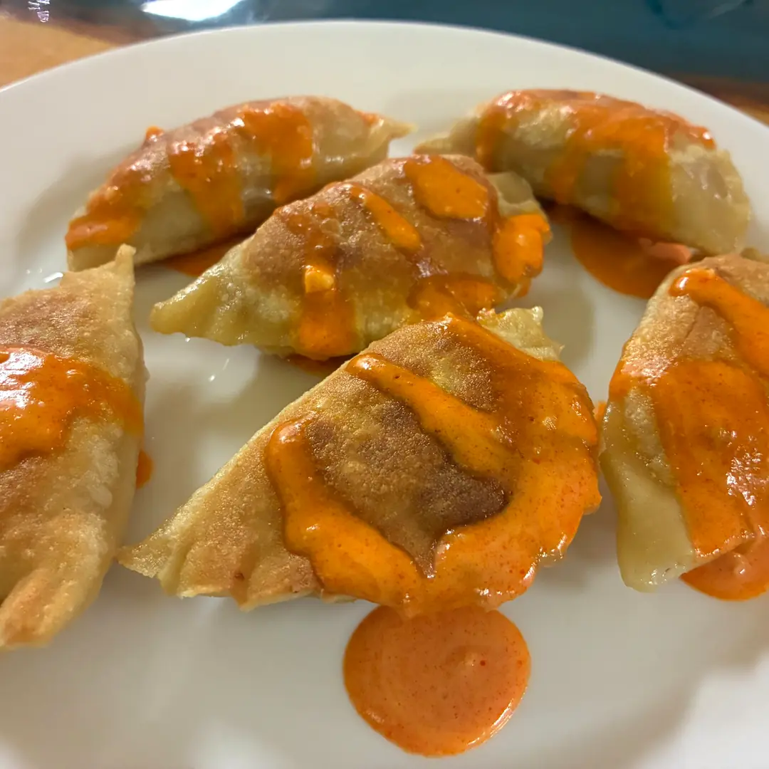Six pan-fried Buffalo Chicken Pierogies drizzled with orange Buffalo sauce at Kat’s Café & Restaurant.