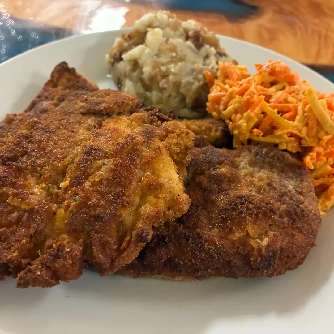 Crispy breaded chicken cutlets at Kat’s Café & Restaurant served with mashed potatoes and house-made carrot and apple salad.