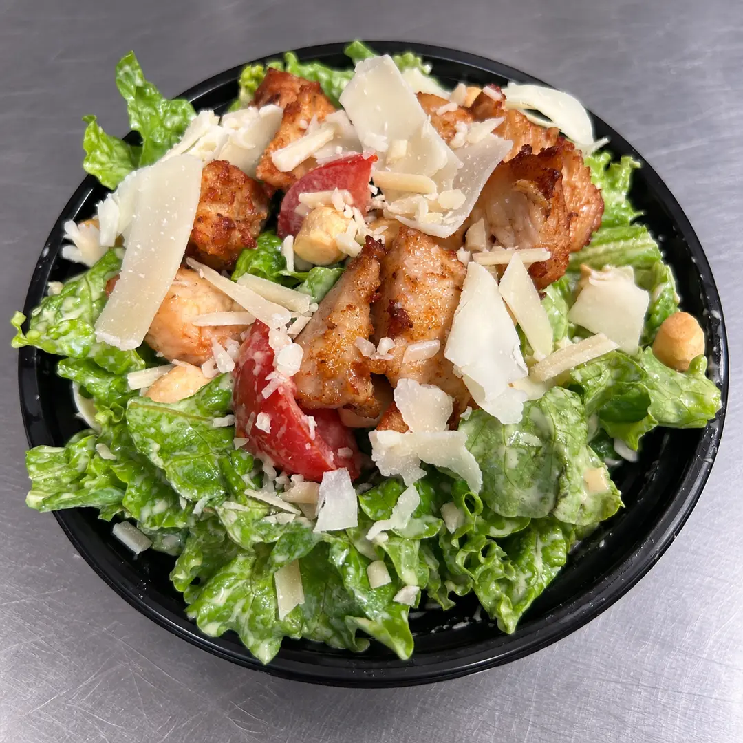 Kat’s Chicken Parmesan Caesar Salad with seasoned chicken, crisp romaine, shaved Parmesan, croutons, tomatoes, and house-made Caesar dressing at Kat’s Café & Restaurant.
