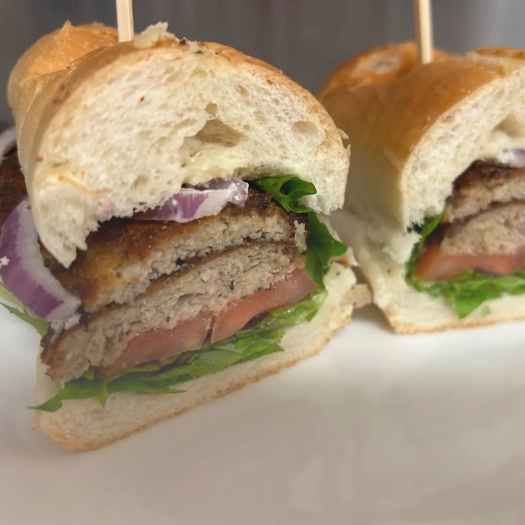City Chicken Sub at Kat’s Café & Restaurant with stacked golden-brown patties, lettuce, tomato, red onion, and mayonnaise on a fresh hoagie roll.