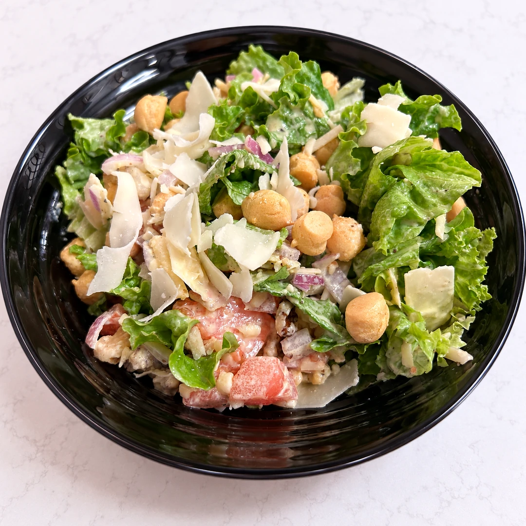 Parmesan Caesar Salad at Kat’s Café & Restaurant with crisp romaine, shaved Parmesan, croutons, tomatoes, red onion, and creamy Caesar dressing.