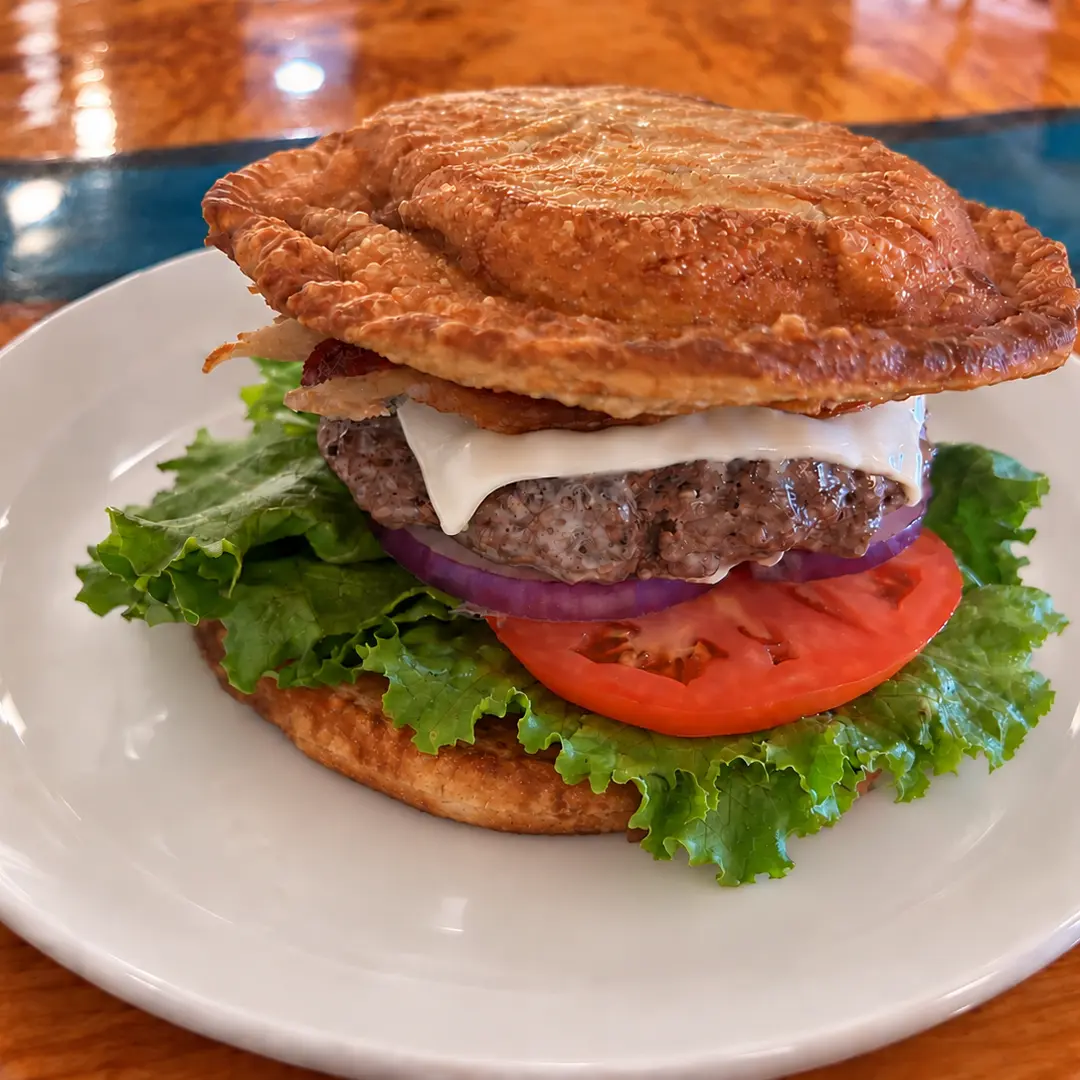 Pierogi Smash Burger with beef, bacon, lettuce, tomato, mayonnaise, and red onion served between two extra-large fried potato-and-cheese pierogies at Kat’s Café & Restaurant.