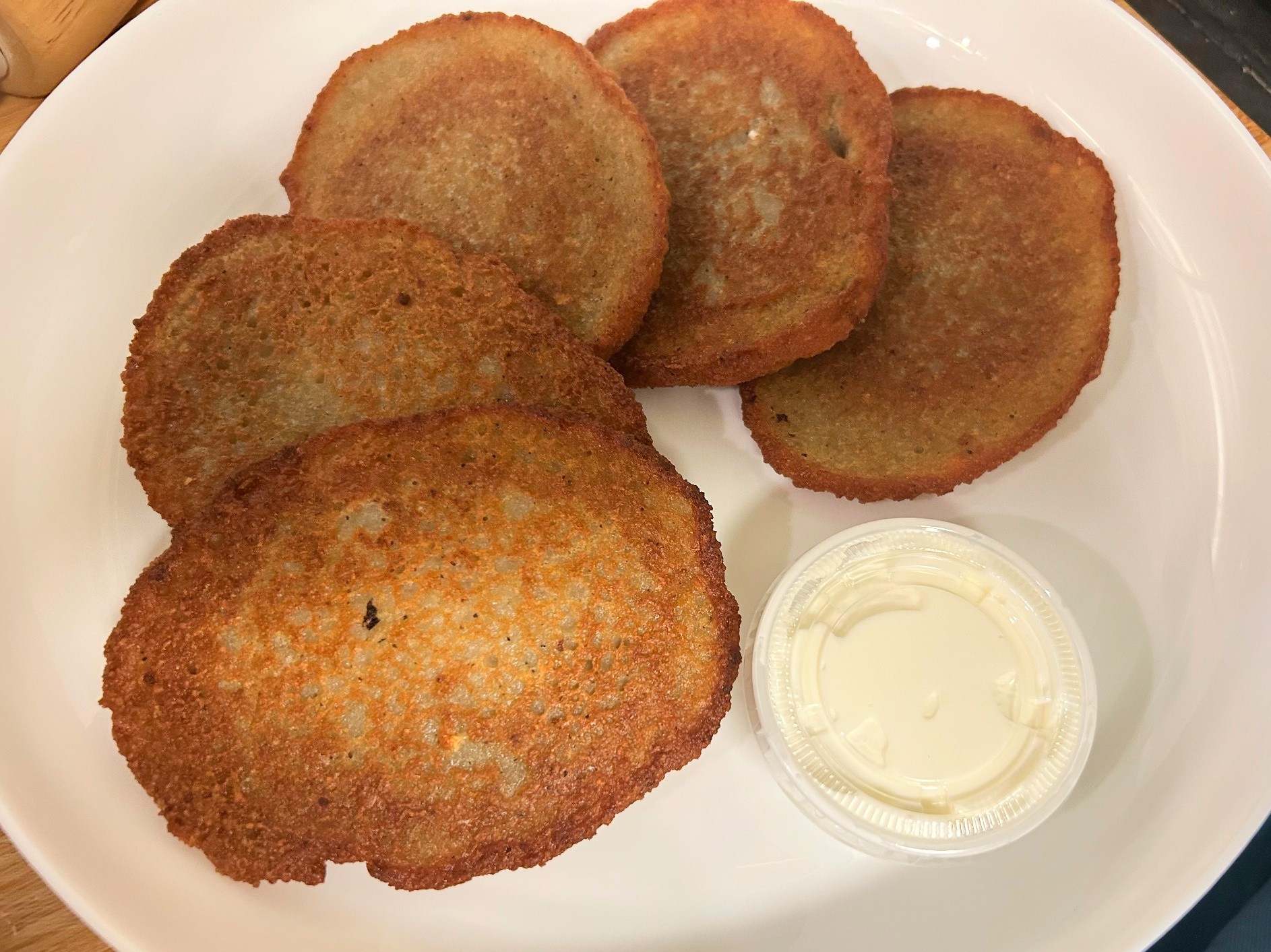 Five golden-brown, house-made potato bleenies at Kat’s Café & Restaurant, served with a side of sour cream.