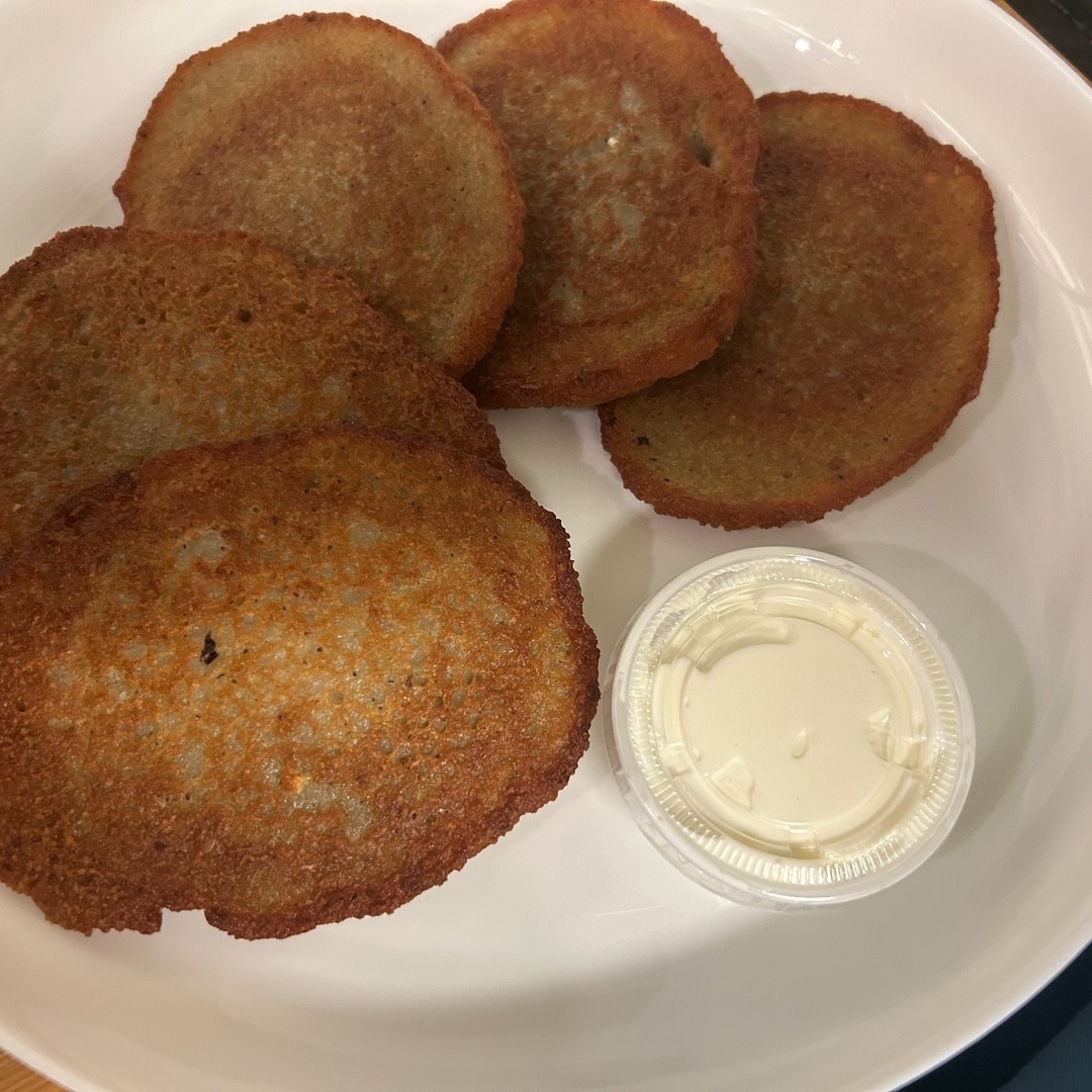Five golden-brown, house-made potato bleenies at Kat’s Café & Restaurant, served with a side of sour cream.