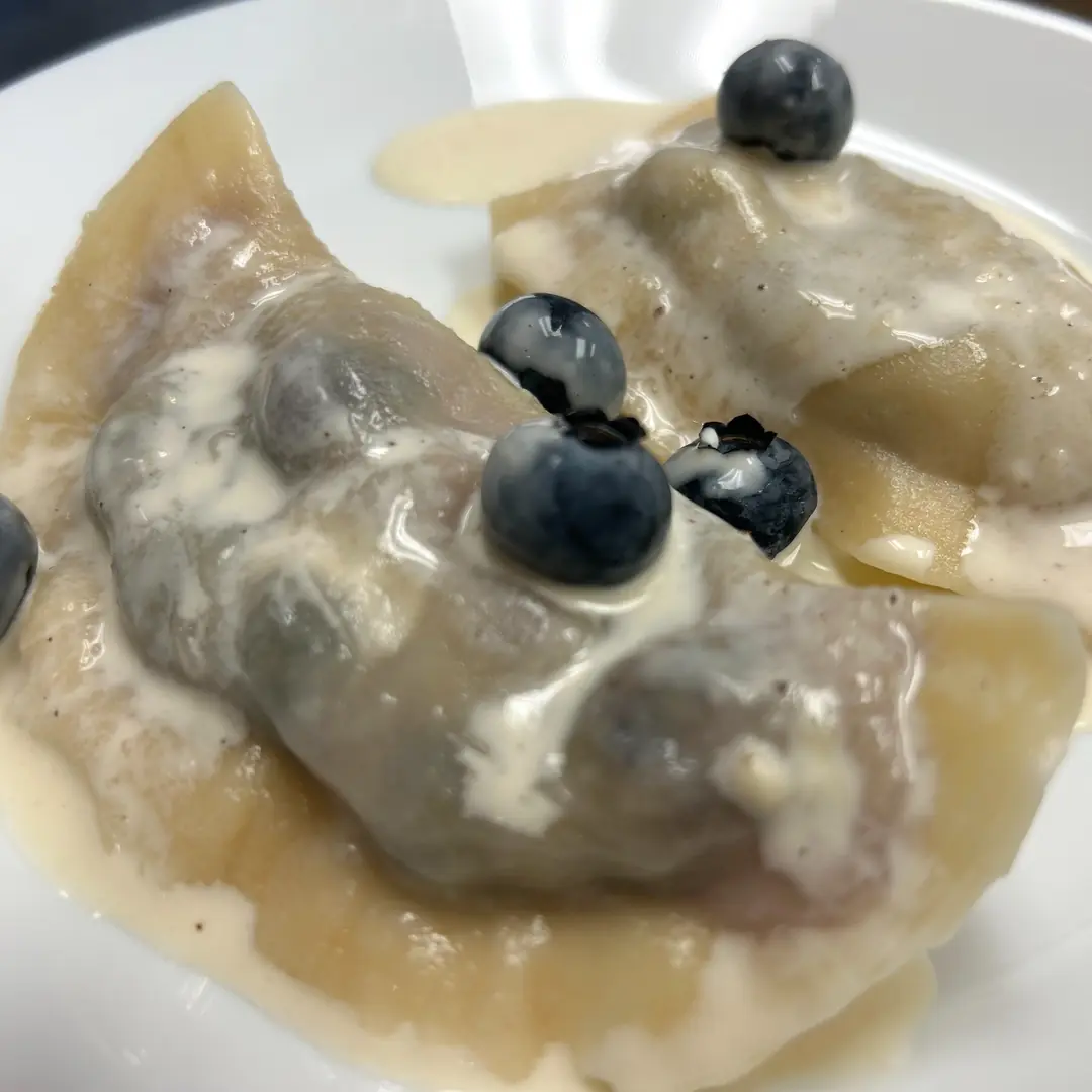 Handmade seasonal blueberry pierogies at Kat’s Café & Restaurant, with sweet cream sauce and fresh blueberries.