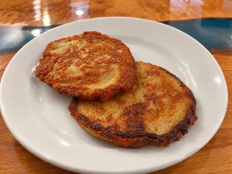 Two golden-brown potato bleenies at Kat’s Café & Restaurant, with crisp edges, overlapping on a white plate.