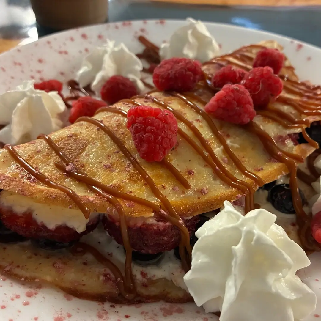 Freshly made sweet cheese crepe at Kat’s Café & Restaurant filled and topped with assorted fresh fruit, finished with sauce and served with whipped cream.