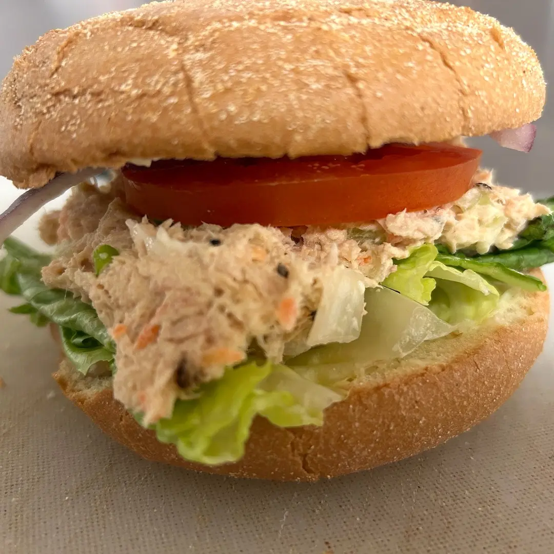 Homemade tuna salad sandwich at Kat’s Café & Restaurant with lettuce, tomato, and red onion on a fresh roll.