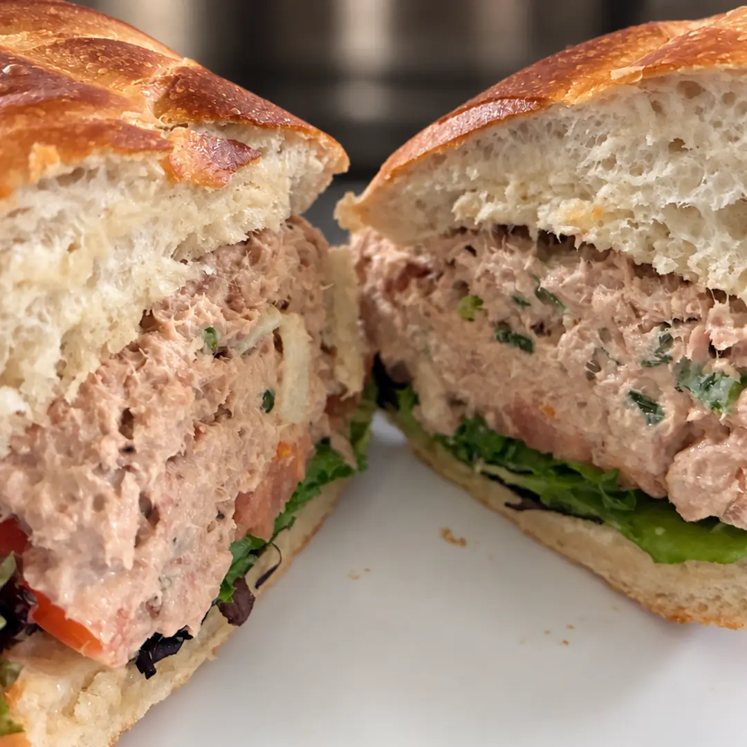 Homemade tuna salad sub at Kat’s Café & Restaurant with lettuce and tomato, served in two generously filled halves on a white plate.
