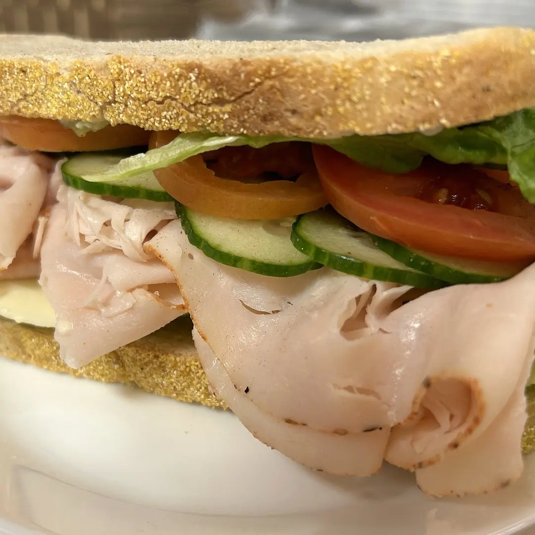 Turkey sandwich at Kat’s Café & Restaurant on rye bread with cheese, lettuce, tomato, and cucumber.